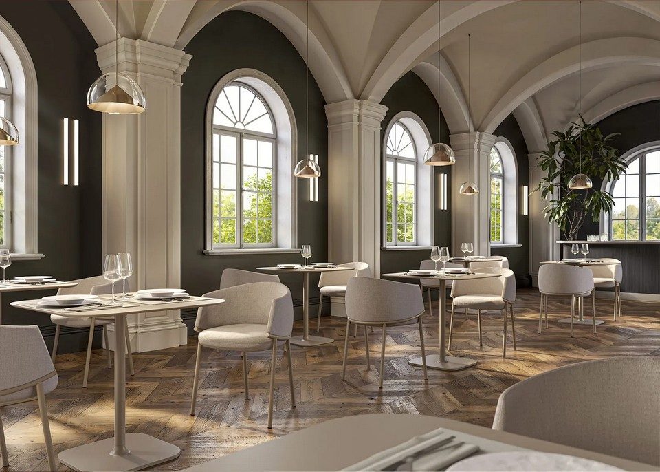 Vue d'ensemble d'une salle de restaurant voûtée avec plusieurs ensembles de chaises KOALA beiges et tables carrées assorties