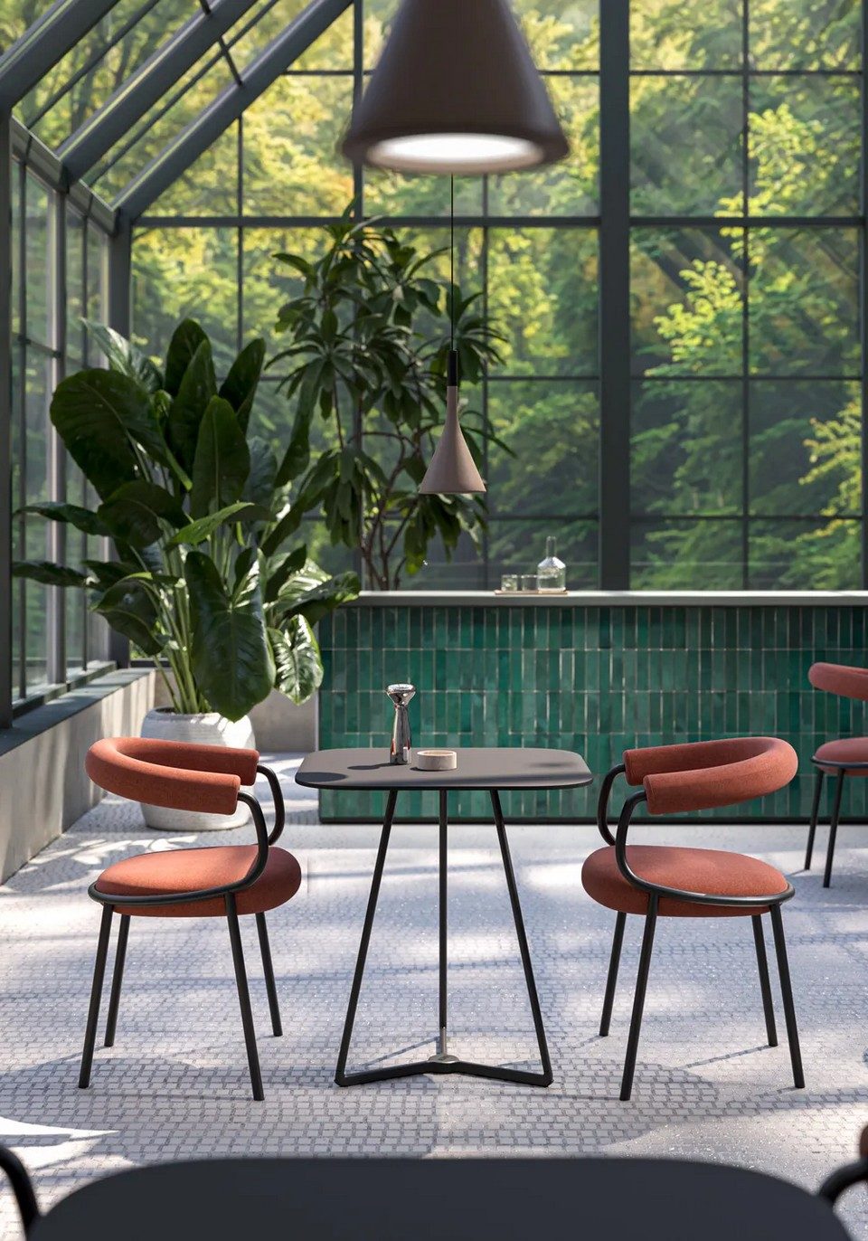 Ambiance de restaurant sous verrière avec deux chaises KOALA OPEN terre cuite autour d'une table noire face à un comptoir en carrelage émeraude