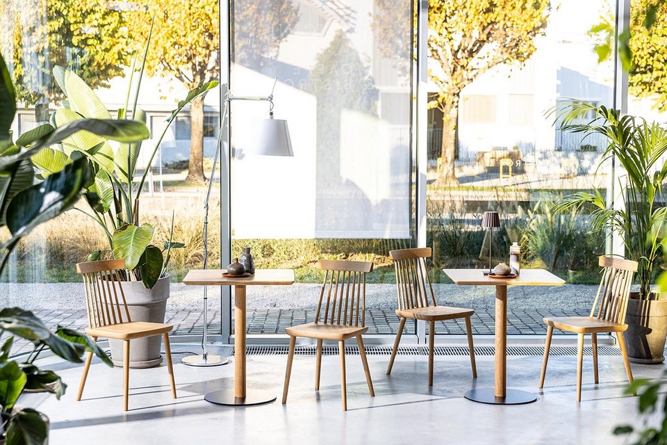 Aménagement biophilique d'un restaurant avec la table TREE en bois naturel massif.