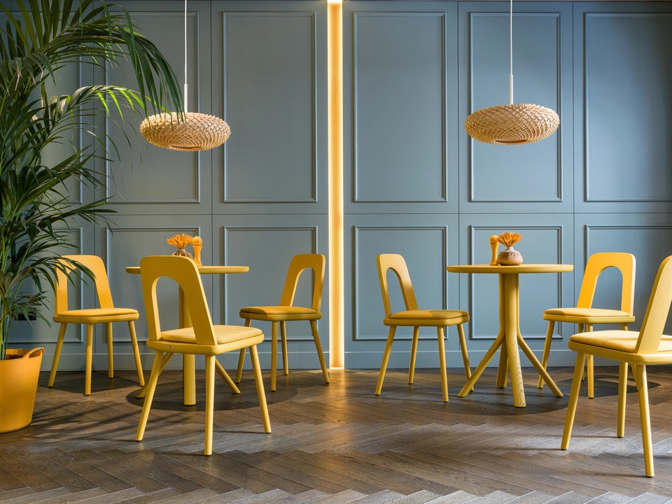 Aménagement d'une salle de restaurant avec tables TREE et chaises jaunes audacieuses.