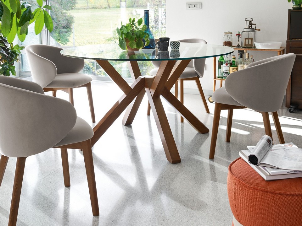 Chaises de réunion TUKA en velours gris avec piètement bois disposées autour d'une table en verre dans un environnement lumineux.