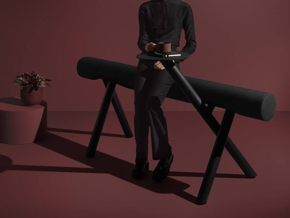 Banc LUMBER noir avec tablette intégrée dans une mise en scène monochrome bordeaux