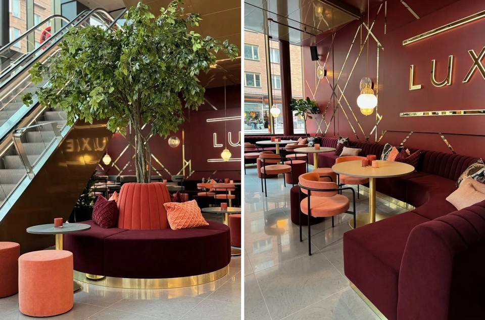 Banquette ADRENALINE incurvée en velours bordeaux, intégrée dans un restaurant lounge de luxe, avec poufs corail et décor mural doré.