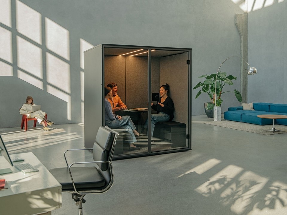 Réunion informelle et confidentielle dans la cabine acoustique BERLIN MEET, intégrée au cœur d'un grand open space lumineux.