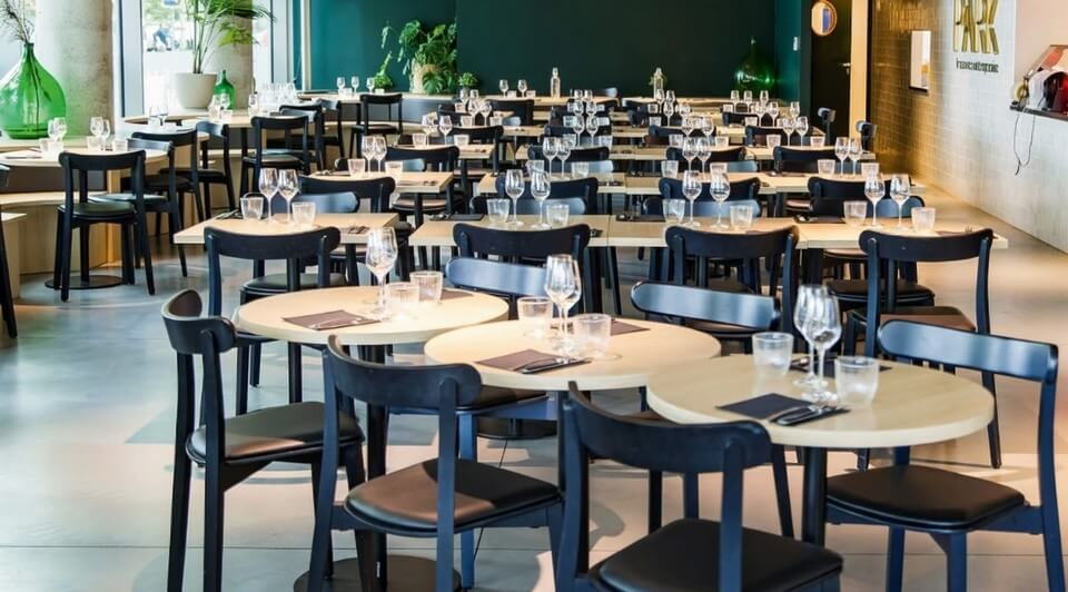 Aménagement de restaurant autour de chaises ICHO en bois foncé, créant une ambiance chaleureuse et élégante pour la clientèle.