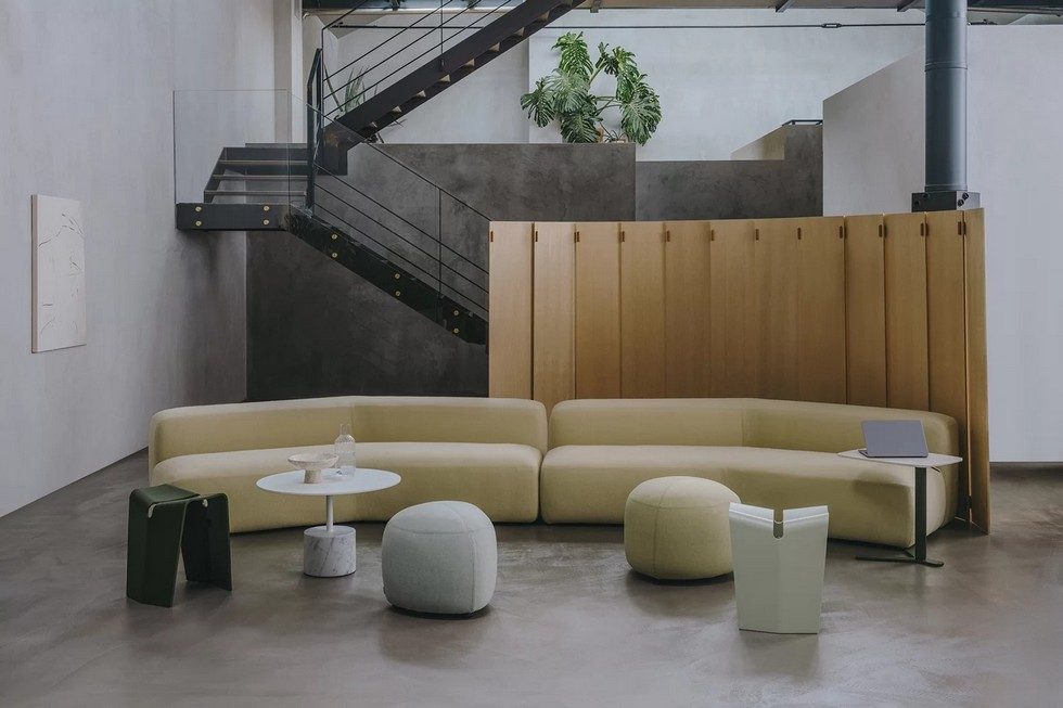 Grand séparateur d'espace en bois massif WOD structurant une zone d'attente lounge design dans un hall d'accueil type industriel.