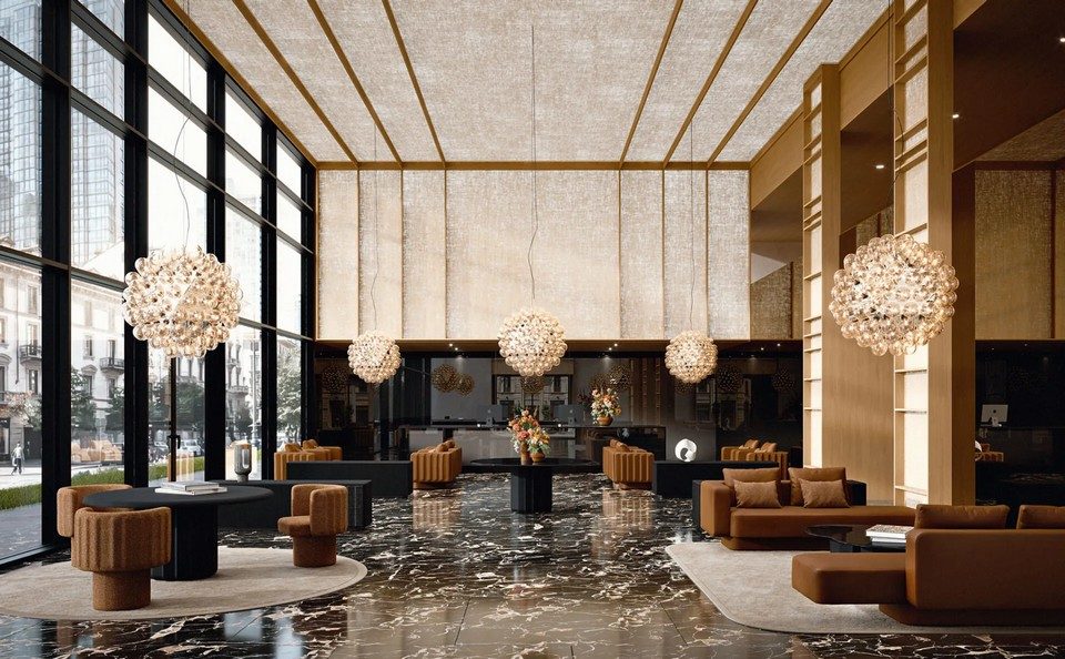 Vue panoramique d'un hall d'hôtel de luxe agencé avec la collection de tables, canapés et fauteuils SABREE. Canapés en velours marron et fauteuils flûtés sur un sol en marbre noir brillant.