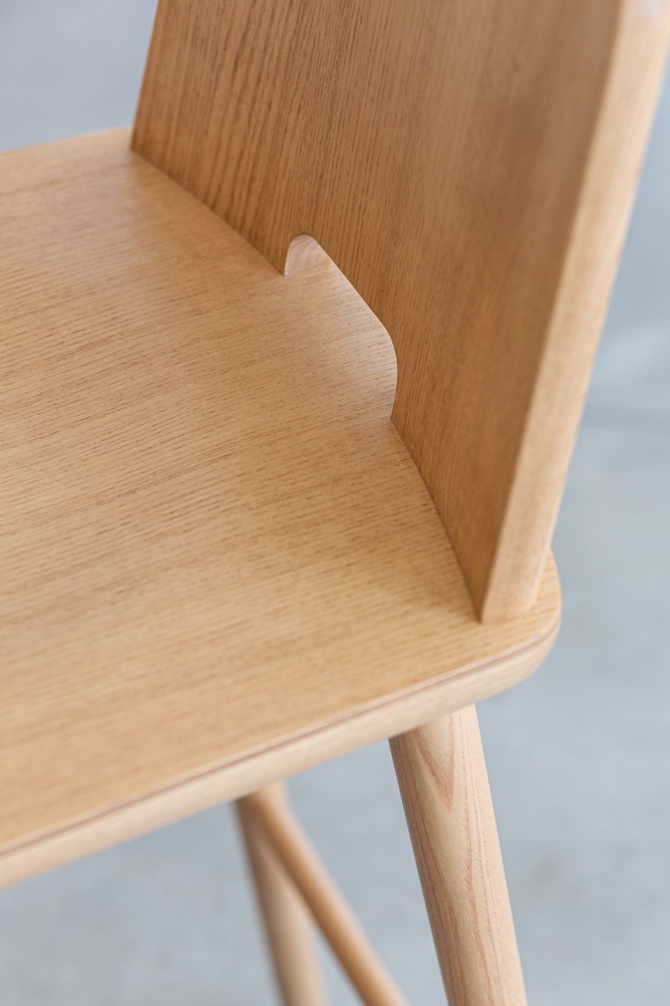 Gros plan sur la réservation du dossier de la chaise TABLET, un détail pratique et esthétique pour la prise en main.