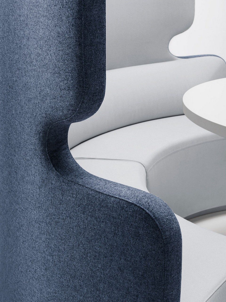 Gros plan sur les finitions tapissées et le dossier haut profilé du canapé circulaire TALK en tissu bicolore bleu et gris, illustrant la qualité d'absorption phonique pour l'agencement d'open space.