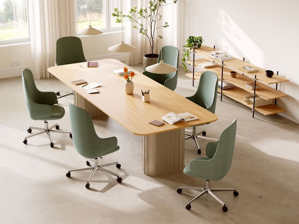 Espace de travail lumineux équipé de fauteuils OSKOL verts autour d’une grande table de réunion