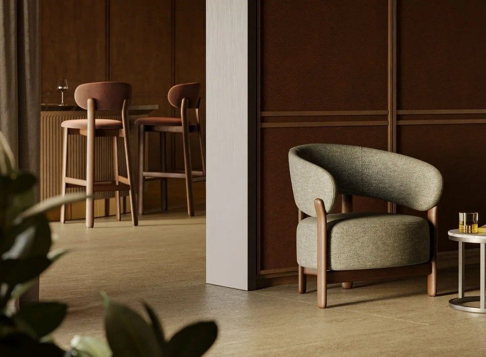 Fauteuil lounge bas en tissu texturé gris vert BAOBAB à côté d'une table basse dans un espace lounge d'hôtel.