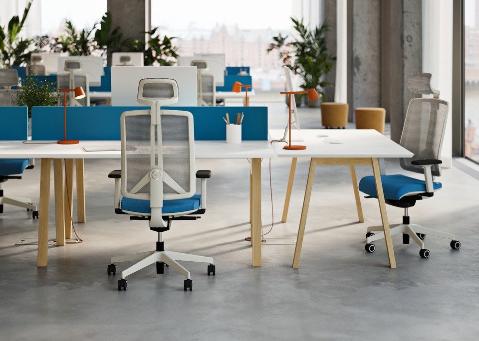 Aménagement d'un open-space moderne avec des fauteuils de bureau ergonomiques FLEXI à structure blanche et assise bleu azur, installés devant des bureaux bench en bois et blanc dotés d'écrans acoustiques séparateurs.