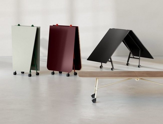 Tables de réunion pliées verticalement, illustrant le faible encombrement des tables TT sur roulettes design avec structure et plateau colorés