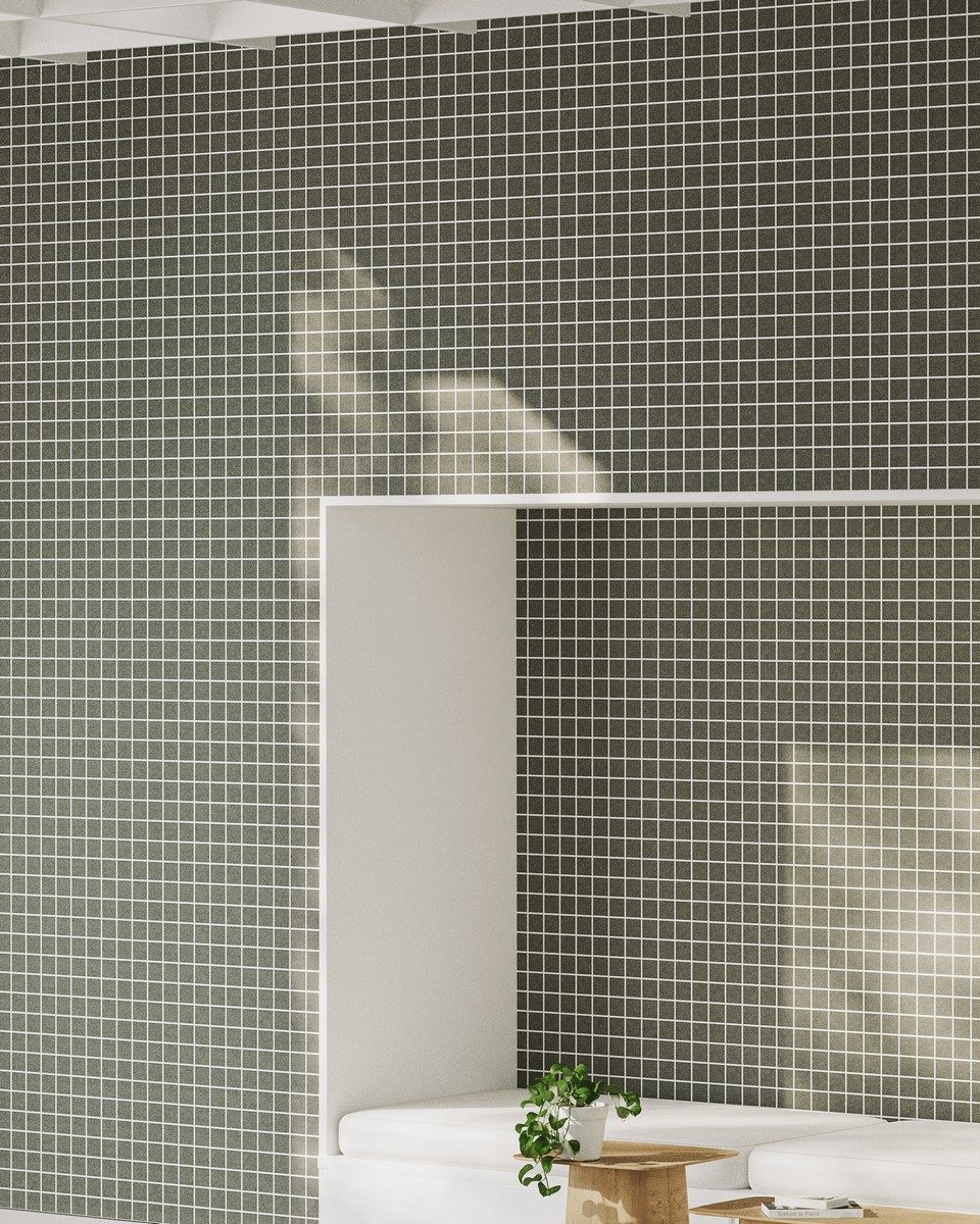 Revêtement acoustique mural en feutre de PET recyclé vert olive à motif de petit quadrillage linéaire blanc. Une alcôve blanche intègre une banquette épurée et une table basse en bois devant ce traitement absorbant. Solution de correction phonique et d'insonorisation pour l'architecture d'espaces professionnels tertiaires.