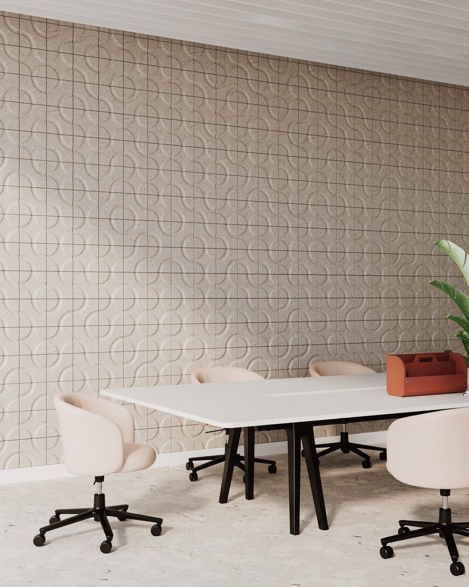 Grand habillage mural composé de dalles acoustiques modulaires Truchet en fibres naturelles beige dans une salle de réunion moderne équipée d'une grande table blanche et de chaises de bureau roses. Optimisation phonique architecturale et correction sonore écoresponsable pour le confort des espaces tertiaires collaboratifs.