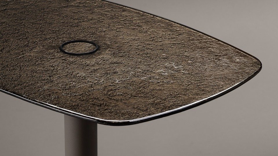 Zoom sur le plateau en verre trempé arrière nickelé de la table KOBI révélant sa texture organique d'inspiration Murano.