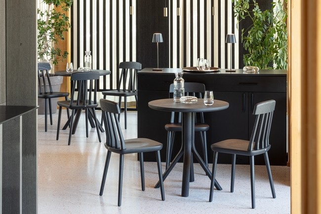 Aménagement complet d'une salle de restaurant avec tables de bistrot TREE noires et chaises en bois assorties.