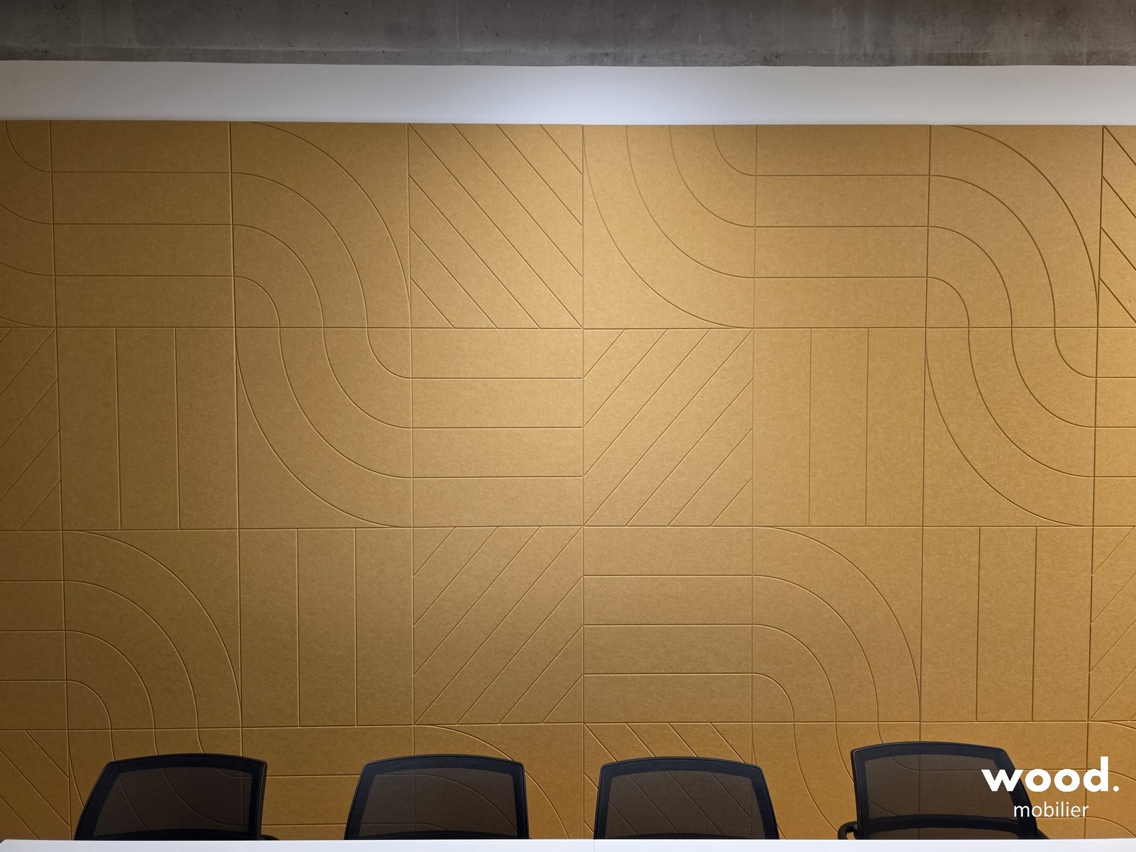 Grande surface murale acoustique jaune soleil traitée en PET recyclé pour salle de conférence avec écran dynamique.