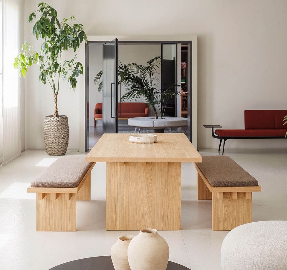 Table de réunion ESSENCE en bois clair avec bancs – mobilier direction minimaliste dans un espace lumineux végétalisé et une cabine acoustique qui propose un mélange des genres